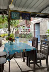 A short, handheld video showcasing a rustic, authentic Thai food stall in Koh Samui. The video features the outdoor kitchen, the cook preparing food, and the final dish served on a Hello Kitty tablecloth, highlighting the local, unpretentious atmosphere.