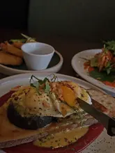 A personal review of a garden centre cafe, featuring a variety of dishes including a chicken salad, eggs benedict, hash browns, and coffee. The creator shares their positive experience and highlights the healthy options available.