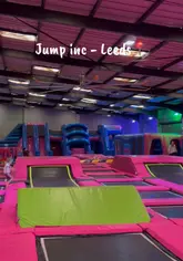 People jumping and playing on trampolines and a large inflatable obstacle course at Jump Inc Leeds.