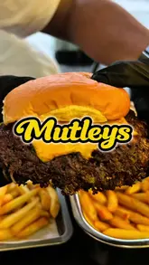A high-energy food review video featuring a creator visiting Mutleys in Barking, London. The video focuses on a 'Sylheti' smash burger, Saudi-style broasted chicken, and BBQ loaded fries, providing a taste test and enthusiastic commentary on the quality and flavor of the food.