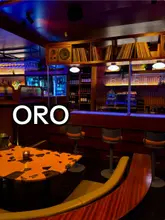 Mid-century Italian interior of ORO Restaurant Shawlands, Glasgow, with terrazzo tables, olive green booths & a hand-painted mural.