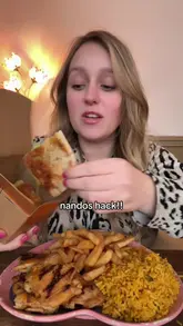 Close-up of hands eating Nando's peri-peri chicken with a cheesy garlic pitta bread hack, featured in a mukbang eating video.