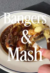 A hearty plate of bangers and mash, featuring grilled sausages and creamy mashed potatoes covered in rich gravy.
