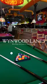 People enjoying bowling and playing pool at the lively Wynwood Lanes entertainment venue in Manchester.
