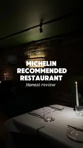 Plates of modern fine dining dishes, including tempura scallop, lamb saddle, and apple tart tatin, served in a Glasgow restaurant with an open kitchen.