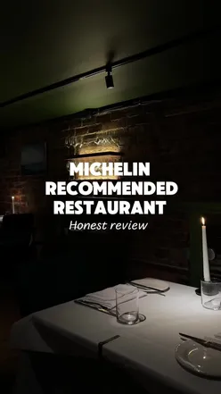 Plates of modern fine dining dishes, including tempura scallop, lamb saddle, and apple tart tatin, served in a Glasgow restaurant with an open kitchen.