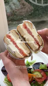 A vlog-style review of Street Lane Bagel Bakery in Leeds, featuring a tour of the shop's bagel selection, a look at the sandwich preparation, and a taste test of their smoked salmon and cream cheese bagels and a cinnamon slice.