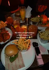 A lively, music-synced montage showcasing a bottomless brunch experience at The Blues Kitchen. The video features a group of friends enjoying cocktails, dancing to R&B music, and eating brunch dishes like burgers and wings in a dimly lit, atmospheric venue.