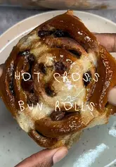 Freshly baked Hot Cross Bun Rolls with white icing crosses and swirls, a sweet Easter treat.