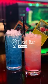 Two friends playing Nintendo Switch and drinking unique video game-themed cocktails at the immersive Pixel Bar in Leeds.