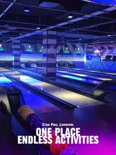 A promotional video for Star Pins in Liverpool, showcasing the various entertainment options available including bowling, ice-free curling, AR darts, shuffleboard, and arcade games, alongside casual food options like pizza and chicken wings.