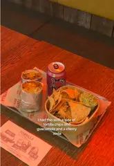 Person holding a delicious, wrapped Tortilla burrito, promoting a free National Burrito Day offer.