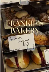 A fresh croissant and coffee on a table inside Frankie's, a cosy neighbourhood bakery in Chiswick, London.