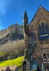 Rooftop bar at Cold Town House, Edinburgh, featuring outdoor tables, seating, and city skyline views.