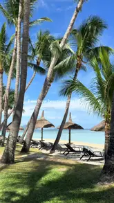 A travel montage featuring a couple enjoying a luxury holiday in Mauritius, including beach activities, swimming, golf, and dining at resort venues.