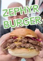 A mouth-watering burger with a juicy patty, melted cheese, and fresh toppings at Zephyr Burgers, Plymouth.