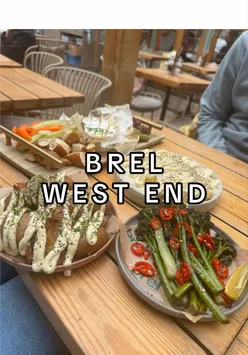 Tapas-style sharing plates: crispy potatoes, poutine, broccoli & baked Camembert on tables in Brel's Glasgow beer garden.