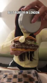Close-up of a juicy, stacked gourmet burger with toppings, hailed as the best by the reviewer, from a London eatery.