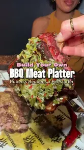 A food review reel showcasing a 'build your own' BBQ meat platter and various starters at a restaurant called Firestarter. The video features close-up shots of the food, including scallops, burrata with nduja, and various meats, accompanied by a voiceover review.