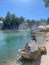 A multi-tiered Kravica Waterfall in Bosnia & Herzegovina, surrounded by lush green foliage and calm turquoise waters.