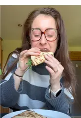 A home cooking tutorial demonstrating how to make a high-protein, gluten-free egg wrap. The creator walks through the ingredients and cooking steps, including whisking eggs, frying bacon, adding toppings, and folding the wrap.