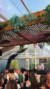 People dancing and enjoying food and drinks at Freight Island's outdoor Spring Summer Series in Manchester, featuring a DJ.