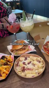 Here are a few options for your SEO alt text, depending on what the image focuses on:

**Option 1 (Focus on the variety):**
A spread of street food including a gourmet burger, loaded fries, pizza, pasta, and ice cream at Platform in Cardiff Bay.

**Option 2 (Action/Location focused):**
Food lover enjoying a variety of meals from Sharkbite Burgers, The Dough Thrower, and more at Platform street food market.

**Option 3 (Concise & Search-friendly):**
Gourmet street food feast featuring burgers, pizza, pasta, and dessert at Platform, Cardiff Bay’s new dining destination.

**SEO Tip:** I recommend **Option 1 or 3** as they include the specific location (Cardiff Bay) and key food terms that people are likely to search for.