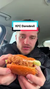 Here are a few options for your alt text, depending on what is most important to highlight:

**Option 1 (Descriptive):**
Close-up of KFC Daredevil menu items including spicy chicken wings and burgers served on a tray.

**Option 2 (Action-focused):**
Someone filming a food review of spicy KFC Daredevil chicken wings and burgers for a mukbang video.

**Option 3 (Concise):**
A variety of spicy KFC Daredevil menu chicken and burger items arranged for a food review.

**SEO Tip:** I recommend **Option 1** as it accurately describes the visual elements (which is the primary goal of alt text for accessibility) while including relevant keywords for search.