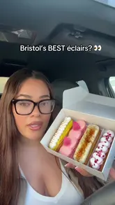 A creator reviews a box of handmade éclairs from a Bristol-based shop, tasting four different flavors: raspberry meringue, crème brûlée, lemon meringue, and cherry macaron.
