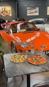 A promotional video for 67 Sourdough, a restaurant located within the Hexagon Classics car showroom in London. The video showcases the unique combination of high-end classic cars, an F1 simulator, and arcade games alongside pizza, charcuterie, and drinks.