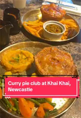 Here are a few options for your SEO alt text, depending on the focus of the photo:

**Option 1 (Focus on the food/dish):**
"Close-up of a delicious curry pie with sides at Khai Khai restaurant in Newcastle."

**Option 2 (Focus on the dining experience):**
"A guest enjoying a Sunday curry pie meal at Khai Khai restaurant in Newcastle upon Tyne."

**Option 3 (Detailed/SEO focused):**
"Old Delhi butter chicken curry pie with sides served at the new Sunday club at Khai Khai restaurant in Newcastle."

**Recommendation:** Go with **Option 1** or **Option 3** as they include the specific location and the key offering (curry pie).