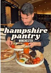 The creator visits Hampshire Pantry in Winchester, providing a review of the venue's brunch offerings, including a sourdough pulled pork sandwich and a 'farmer's breakfast'. The video features shots of the interior, exterior, and close-ups of the food, with the creator sharing his positive impressions of the quality and local produce.