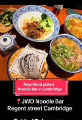 A short, engaging video showcasing a visit to JWD Noodle Bar in Cambridge. The creator highlights the hand-pulled noodle process, the ordering system, and samples several dishes including braised beef biang biang noodles and a beef rougamo.
