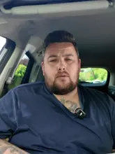 A creator reviews a chicken burger and pork scratchings from Ellie's Sandwich Shop in Sheffield, filmed from inside a car.
