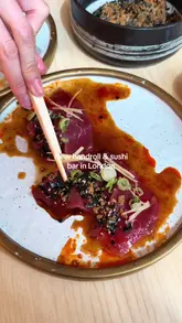 A short, energetic reel showcasing various sushi dishes, including handrolls and crudo, at a Japanese restaurant in London. The video features close-up shots of the food being prepared and eaten, with text overlays identifying the dishes.