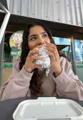A creator visits a Zambrero restaurant to try their spinach tortilla protein burrito, showcasing the assembly process and giving a positive review.