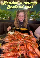A vibrant, fast-paced review of a new seafood restaurant in Brixton, showcasing a variety of dishes including a large seafood platter, lobster cheese bake, and desserts.