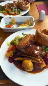 A review video of a Sunday roast at Dyffryn Arms in Neath, featuring shots of the food, the venue interior, and the creators eating. The video highlights the pork and beef roast options and the generous vegetable portions.