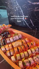 A short, fast-paced promotional video for Iso, a Japanese restaurant in Chorlton. The video features a quick tour of the interior, followed by a montage of various dishes including a sushi boat, bao buns, katsu curry, and mochi, emphasizing the venue's halal status.