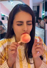 A short, energetic taste test video featuring a creator visiting Snowflake Gelato in London to compare different gelato flavours, specifically a peach-shaped gelato and a chocolate-covered gelato bar.