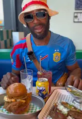 A food review of Kong's Chicken Shop in Manchester, featuring the creator walking to the venue, showing the exterior and interior, and tasting the birria tacos and signature chicken burger.