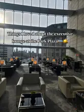 A wide-angle, eye-level shot of a hotel executive lounge, showcasing a modern interior with comfortable armchairs and floor-to-ceiling windows. The primary focus is the expansive view of the London skyline, including Big Ben and the Houses of Parliament, which serves as the main selling point of the venue.