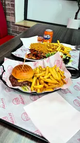 A food review of Adanos Burger in Failsworth, Manchester, where the creator evaluates a beef burger and a butterfly chicken meal, providing a rating and value assessment.