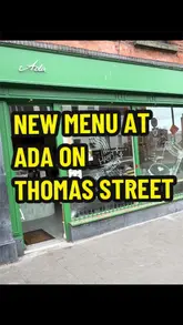 A short, punchy reel featuring a cafe called Ada. It opens with a shot of the storefront, moves to the counter area, and then showcases a Caesar salad bagel and a strawberry matcha drink in close-up shots.