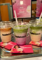 A promotional reel showcasing a collaboration between The MilkCake Man and Huda Beauty at Selfridges Birmingham, featuring themed matcha and latte drinks inspired by a new perfume launch.