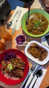 The video is a first-person vlog showcasing a bottomless brunch experience at Rum Kitchen. It features shots of the menu, various Caribbean dishes like jerk chicken and curry mutton, cocktails, and the venue's interior, including a DJ.