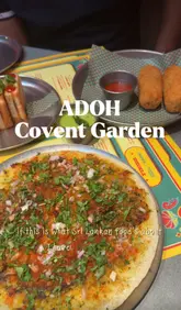 A lively, vlog-style review of ADOH in Covent Garden, featuring two creators trying a variety of authentic Sri Lankan street food dishes, including mutton rolls, crab congee, and chicken curry.