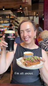 A creator visits Daffodil Mulligan in London, highlighting its Irish ownership and showcasing a variety of dishes including a steak sando, fried chicken, and cocktails, while promoting their lunchtime offer.