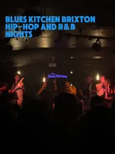A vlog-style video showcasing a Friday night at The Blues Kitchen in Brixton, featuring a live orchestra playing Hip-Hop and R&B, along with cocktails and food.