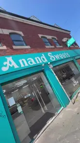 The video features a creator visiting Anand Sweets, an Indian vegetarian restaurant. The reel showcases a wide array of dishes including street food staples like dahi puri, samosas, vada pav, and papdi chaat, as well as main courses like paneer saag, masala dosa, and pav bhaji, finishing with desserts like rasmalai and gulab jamun.